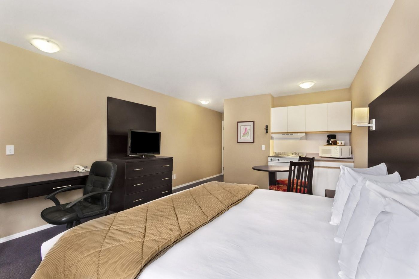 Queen guest room with a desk, coffee station and counter